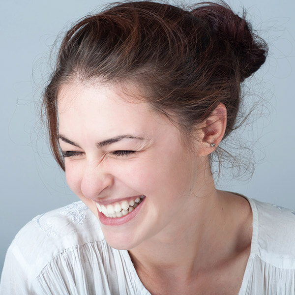 Young woman happily smiling because of her new smile