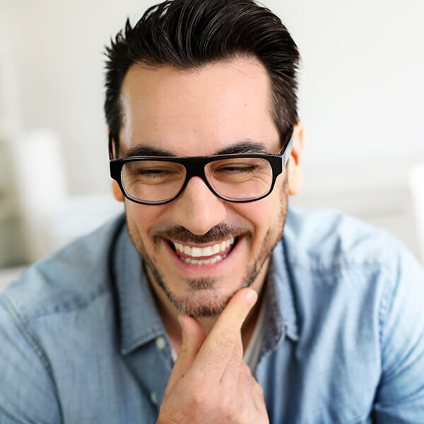 A young man at the dentist's office waiting for his dental exam while smiling